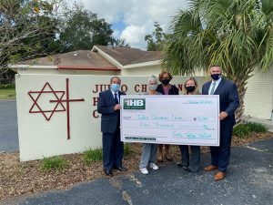 Group of five holding $5,000 check to Judeo Christian Clinic